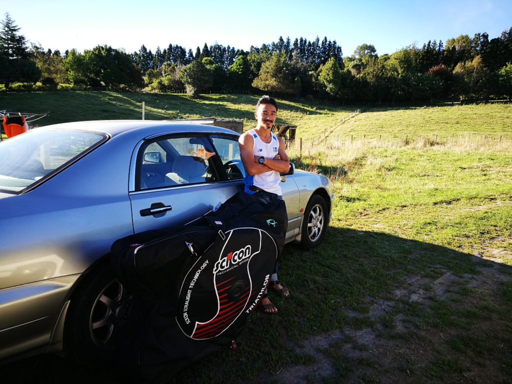 a man standing besides his car with a bicycle