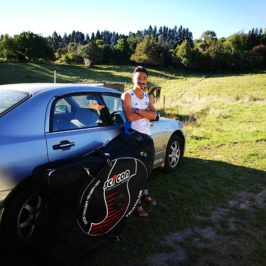 a man standing besides his car with a bicycle