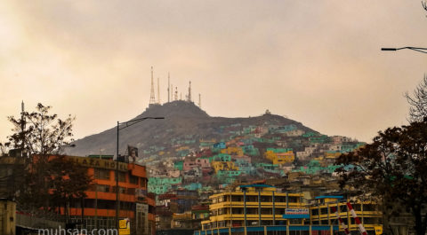 Kabul city with hectic traffic and slump area on the background