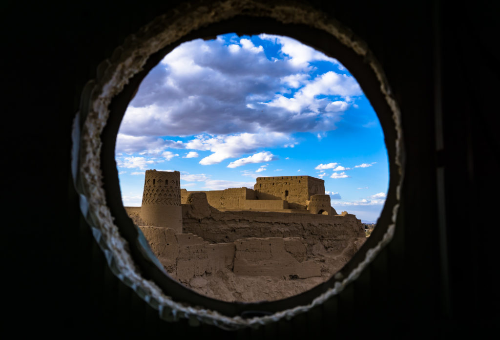 An old castle in Meyboud with cloudy sky viewed from a hole