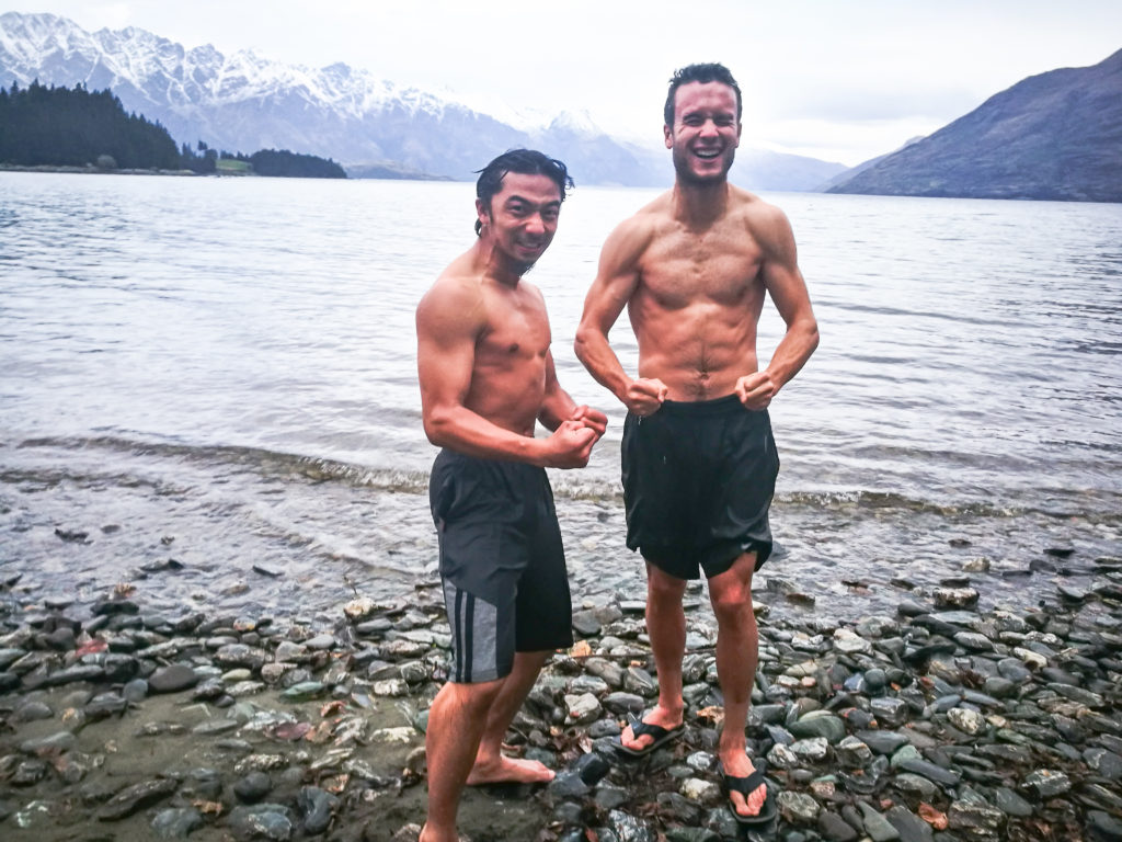 2 guys swimming in a cold lake during winter